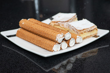 Party platter with arranged sweet desserts from a bakery on banquet table at business or wedding event venue. Sweet food, buffet. Unhealthy food. 