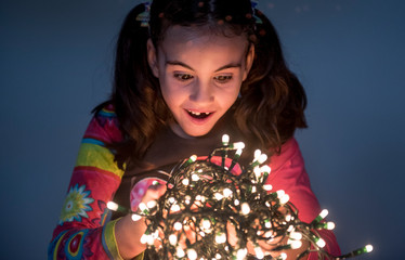 Pretty girl surrounded by christmas light