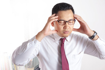 Asian Businessman Working on Laptop at the Office, Tired Stress Gesture