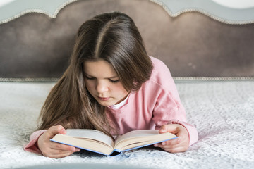 Dziewczynka czyta książkę - obrazy, fototapety, plakaty