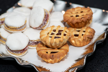 Party platter with arranged sweet desserts from a bakery on banquet table at business or wedding event venue. Sweet food, buffet. Unhealthy food. 