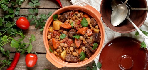 beef stew with chickpeas and vegetables, rich thick stew with potatoes, carrots, tomatoes and paprika. rustic style, homemade simple dish. popular moroccan dish. top view.