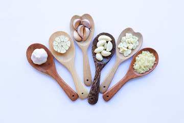 Garlic on wooden spoon on white