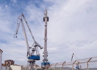 Fototapeta na wymiar Cargo cranes from a shipyard in the port of Gijón.
