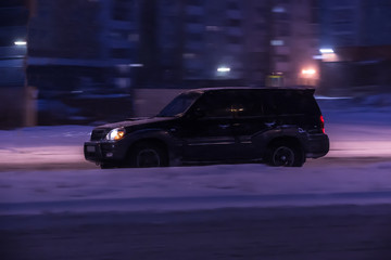 Fototapeta na wymiar SUV moving winter night on city street