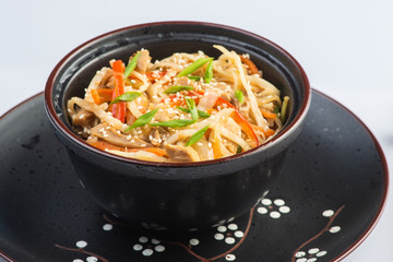 Japanese ramen soup with chicken, egg, chives and sprout on dark wooden background.