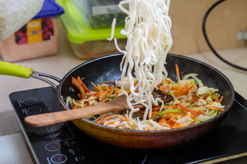 Japanese ramen soup with chicken, egg, chives and sprout on dark wooden background.