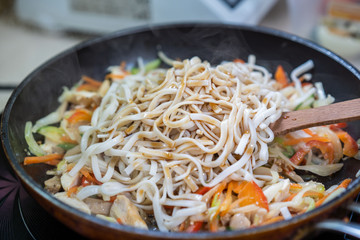 Japanese ramen soup with chicken, egg, chives and sprout on dark wooden background.