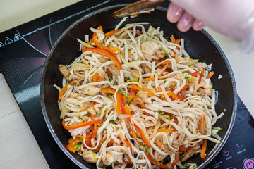 Japanese ramen soup with chicken, egg, chives and sprout on dark wooden background.