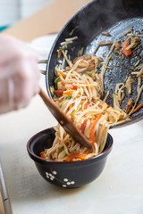 Japanese ramen soup with chicken, egg, chives and sprout on dark wooden background.