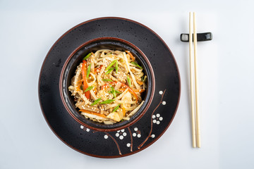 Japanese ramen soup with chicken, egg, chives and sprout on dark wooden background.