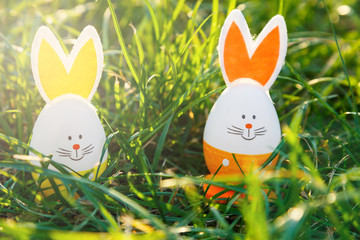 Young Boy in blue shirt holds wooden basket with hand painted eggs in hands at sunlight in spring garden. Egg hunt, spring festive background, decoration for Easter