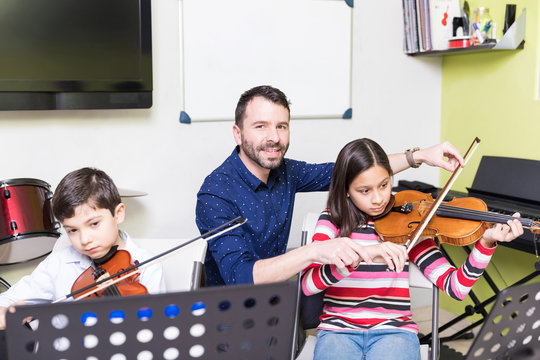 Teacher Helping Girl In Violin Lesson