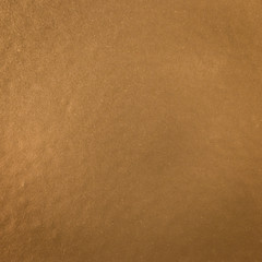Background texture of a shiny metal sheet with a rough stippled textured surface reflecting light. Metal texture