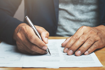 businessman writing on paper report in office