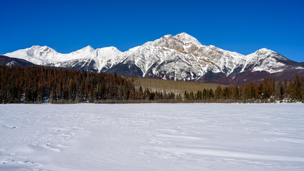 Obraz premium Winter panorama of the Pyramid Mountain and the frozen Patricia Lake in the Jasper National Park Alberta, Canada