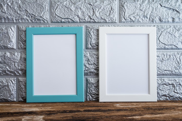 Blue and white photo frame on old wooden table over brick wallpaper background