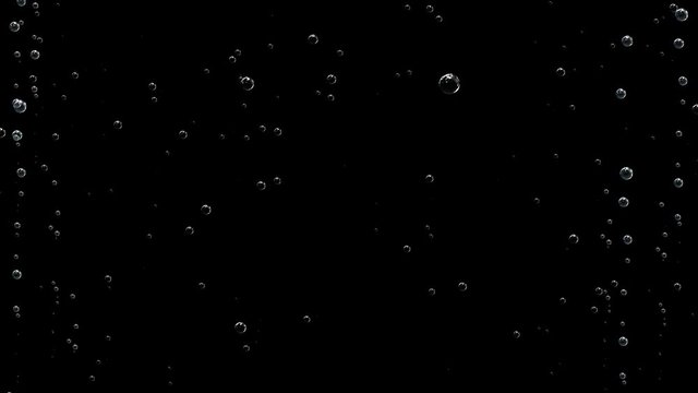 Air bubbles rise up on a black screen. High density of bubbles in the corners of the screen.Pan up following champagne bubbles rising up to top of glass on dark background festive celebration holiday