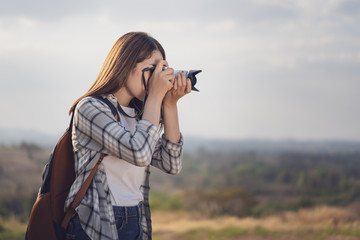 tourist woman taking photo with her camera in nature