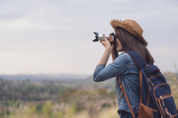 tourist woman taking photo with her camera in nature