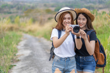 two tourist woman taking a photo with camera in nature