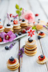 Fruit, berry and pancake canapesFruit, berry and pancake canapes on white wooden table
