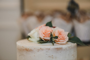 White three tier naked wedding cake with pink, red and white roses