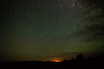Fototapeta premium Green Meteor Over the Clouds with the glow from las Vegas in the background over 300 miles away