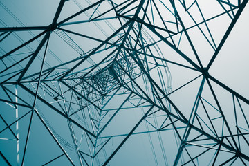Abstract pattern from bottom view of high voltage pole power transmission tower with clear sky...