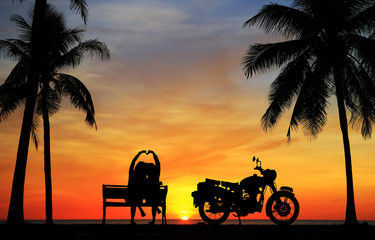 silhouette of lover couple in sunset with classic motorcycle
