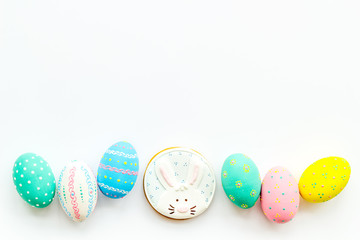 Fototapeta na wymiar Easter symbols. Colorful Easter eggs and gingerbread on white background copy space border