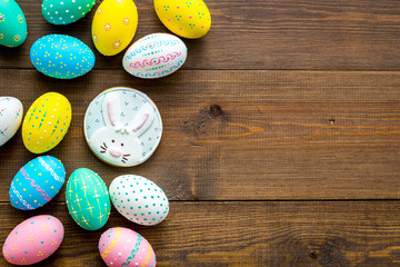 Easter symbols. Colorful Easter eggs and gingerbread on dark wooden background copy space