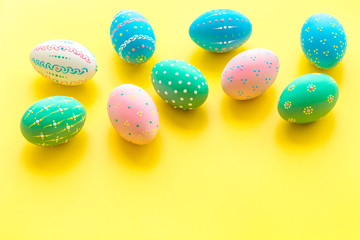 Easter composition. Decorated pastel Easter eggs on yellow background copy space