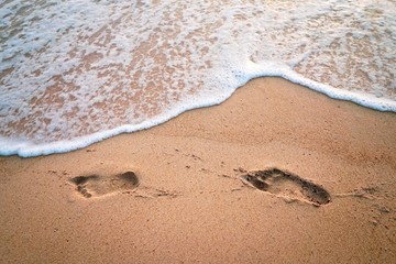 Copy space of footprint on sand beach texture background.