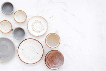 Ceramic tableware pattern. Empty plates and mugs on white background top view copy space