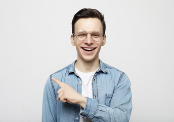 Positive man looks and points at upper right corner with both index fingers