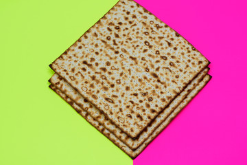 Matzah on yellow pink trendy background.Matza -Jewish traditional Passover unleavened  bread. Pesach celebration symbol.