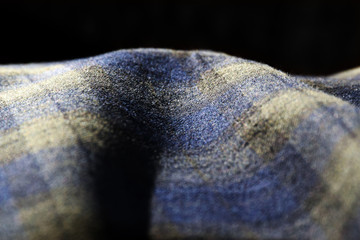 Abstract close up photo of blue and green tartan material in soft sunlight