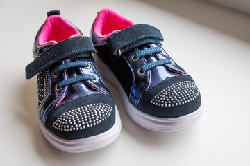 Baby boots, luxury sneakers, sports shoes, boots for girls. Kids trendy footwear with rhinestone decoration. pretty pair of casual baby shoes with a velcro fastening strap.Children's shoes. Moccasins