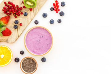 Obraz na płótnie Canvas Preparing healthy fruit smoothie. Acai smoothie bowl near cutting board with fresh fruits, berries, chia seeds on white background top view copy space