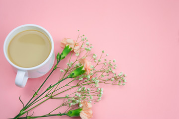 top view coffee with cream and flowers on a pastel pink background