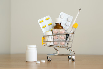 Shopping cart toy with medicaments: pills, blister packs, medical bottles, thermometer set. Health...