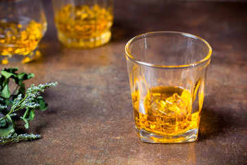 glasses of whiskey with ice cubes  on  bar.
