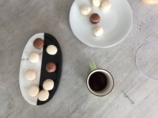Dark and white cholcolate macarons on wooden table