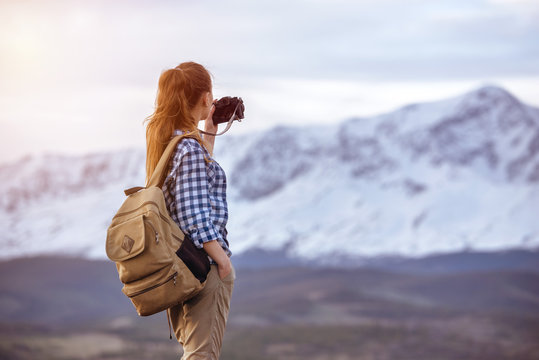 Woman with backpack taking photo of mountain