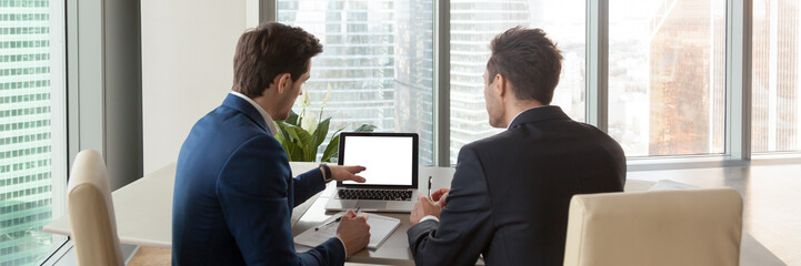 Horizontal rear image businessmen analyzing market pointing on computer screen