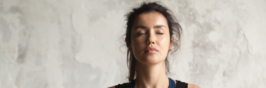 Horizontal image beautiful woman face with closed eyes practicing yoga