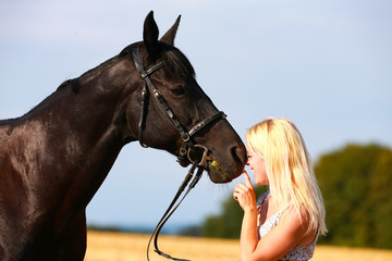 Obraz premium Horse with owner in portrait on a summer field, owner cuddles with her horse.