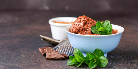 Chocolate ice cream with a bowl on a table.