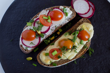 Multigrain toast bread with melt gouda or kaseri cheese and small tomatoes radish and green onion on top